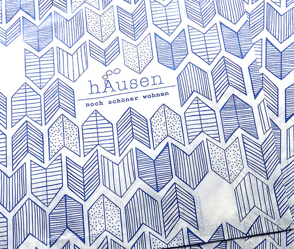 Close-up photo of a store bag pattern featuring a repeated stretched chevron design. Each chevron is filled with a different texture—some with dots, others with horizontal or vertical lines, and some with lines that follow the chevron's shape.